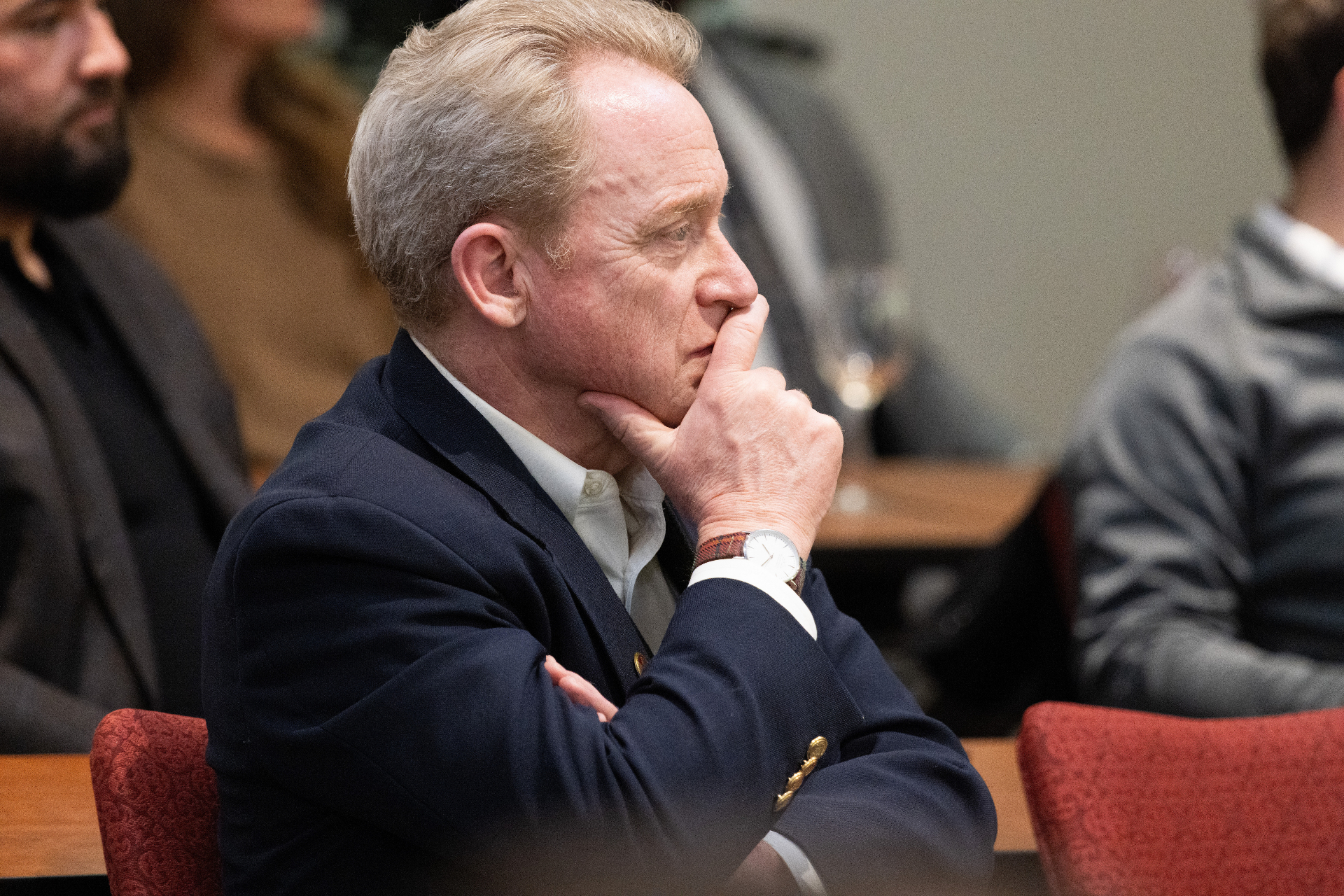 Attendee listening thoughtfully with hand to chin during the airport development panel