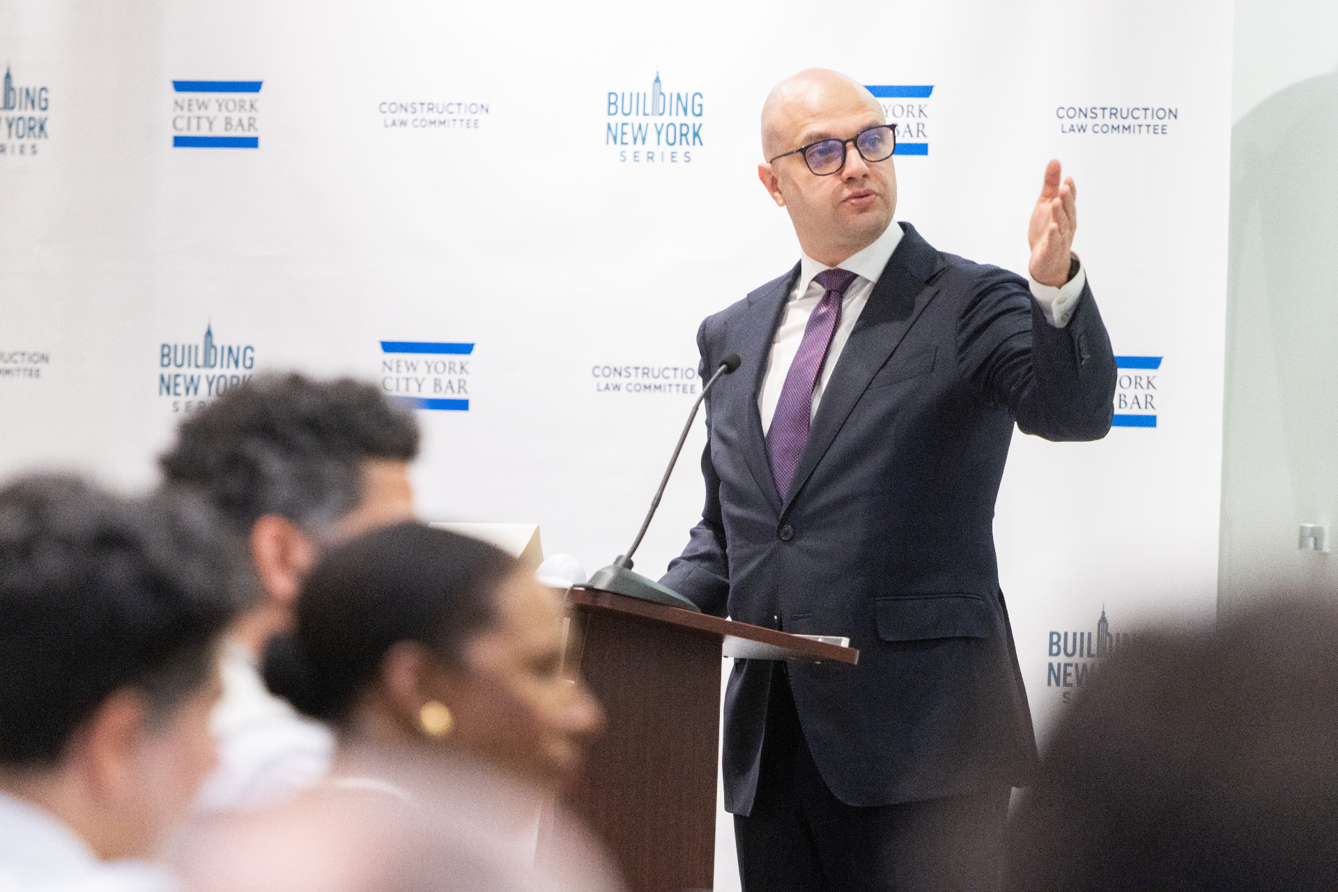 Moderator Max Rayetsky addressing the audience from the podium during the airport development panel