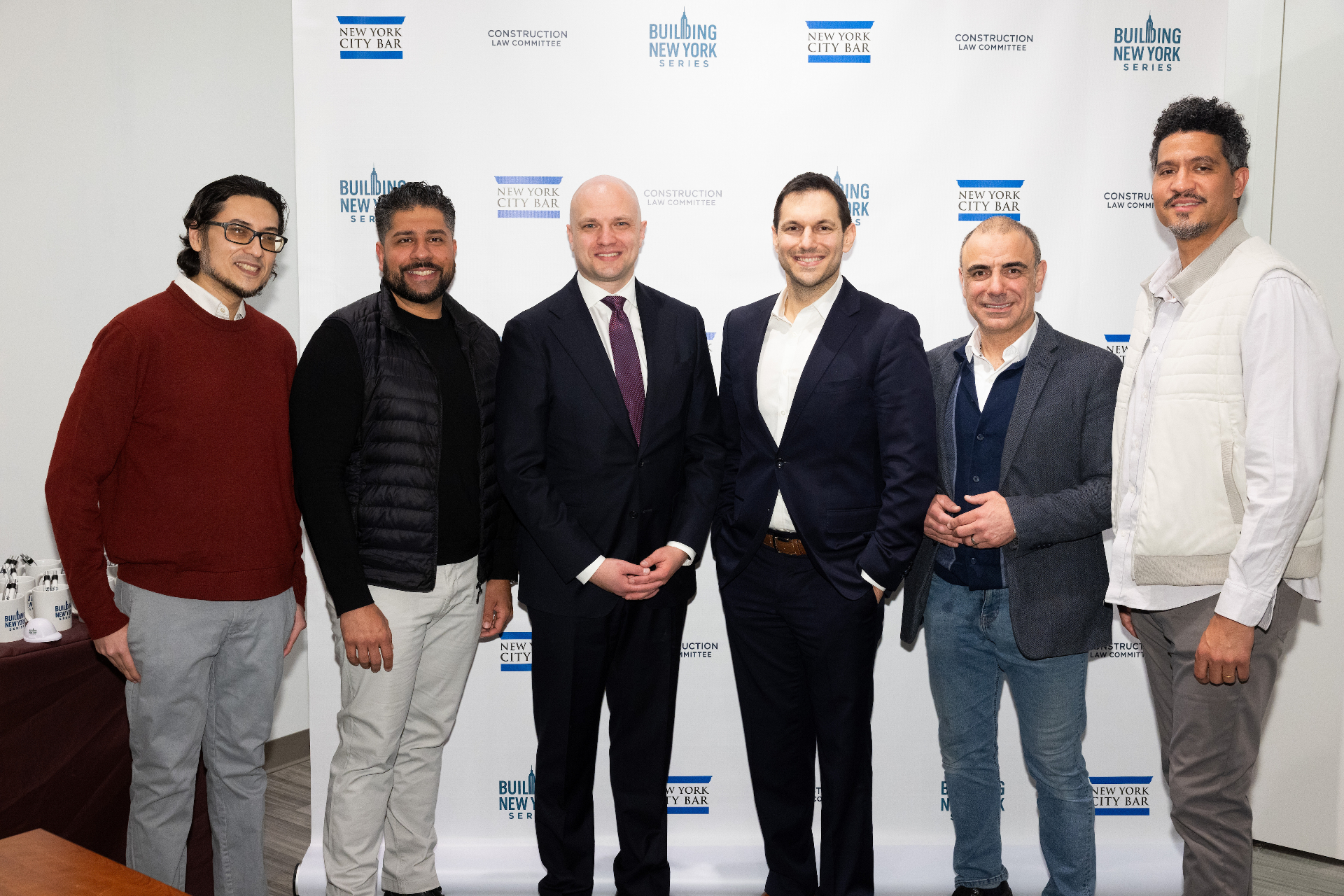 Group photo of panelists and moderator in front of the Building New York Series step-and-repeat