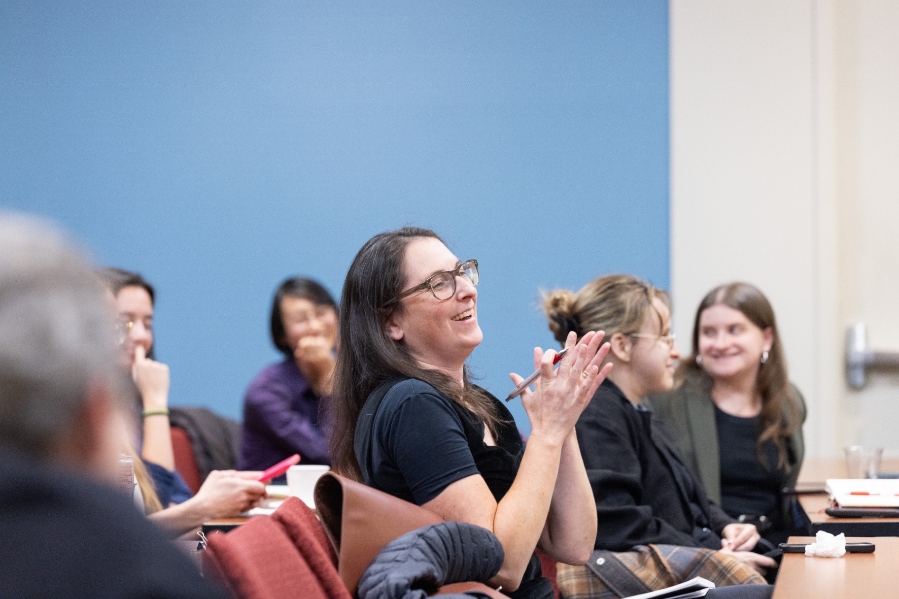 An attendee smiling and asking a question during the audience Q&A