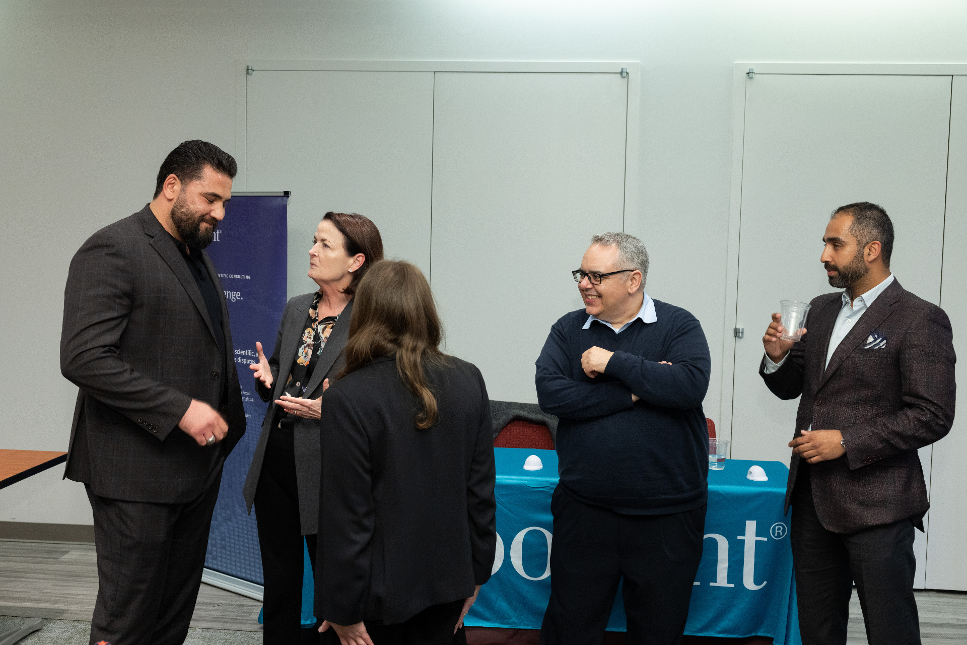 Attendees networking in front of the Exponent banner during the airport development event reception